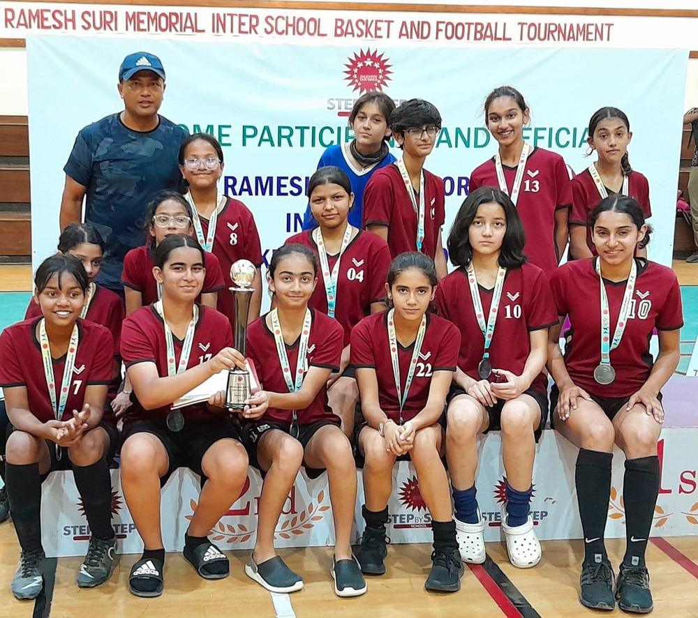The Vasant Valley girls' football team wearing silver medals and holding a trophy at the Ramesh Suri Memorial Inter-School tournament