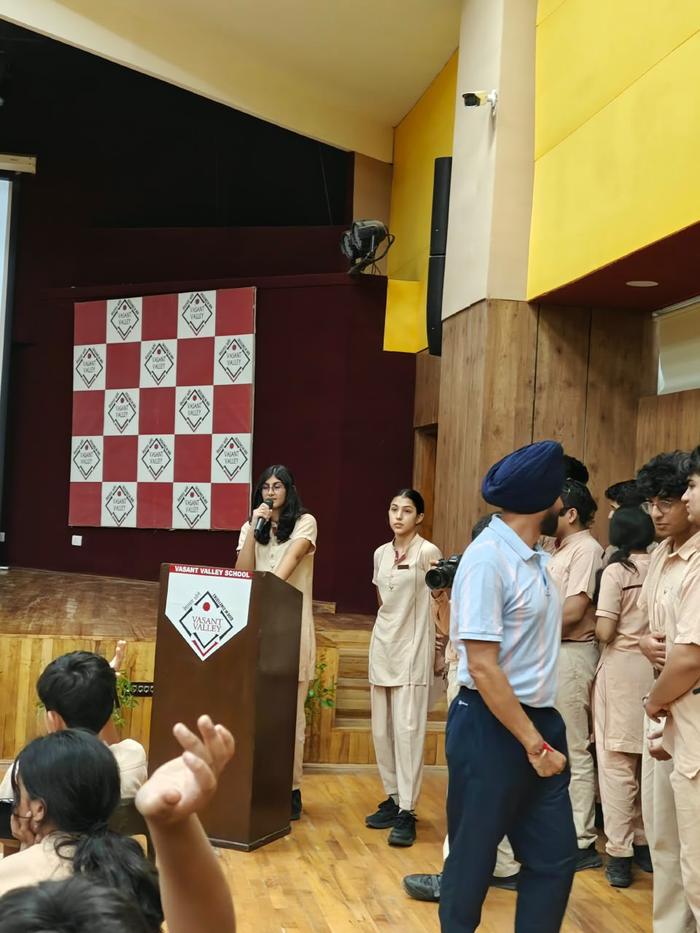 A student speaking into a microphone at a Vasant Valley School podium